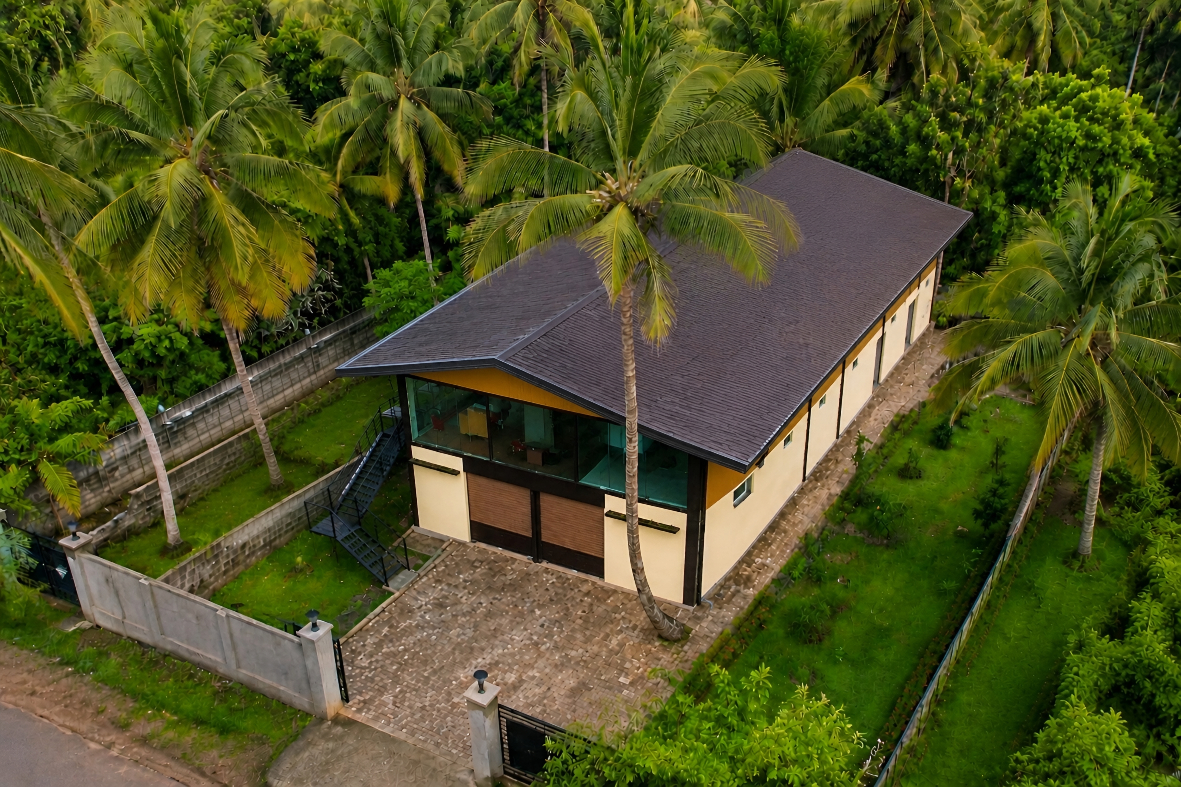 Aerial view of a modern house nestled in a lush tropical coconut palm grove